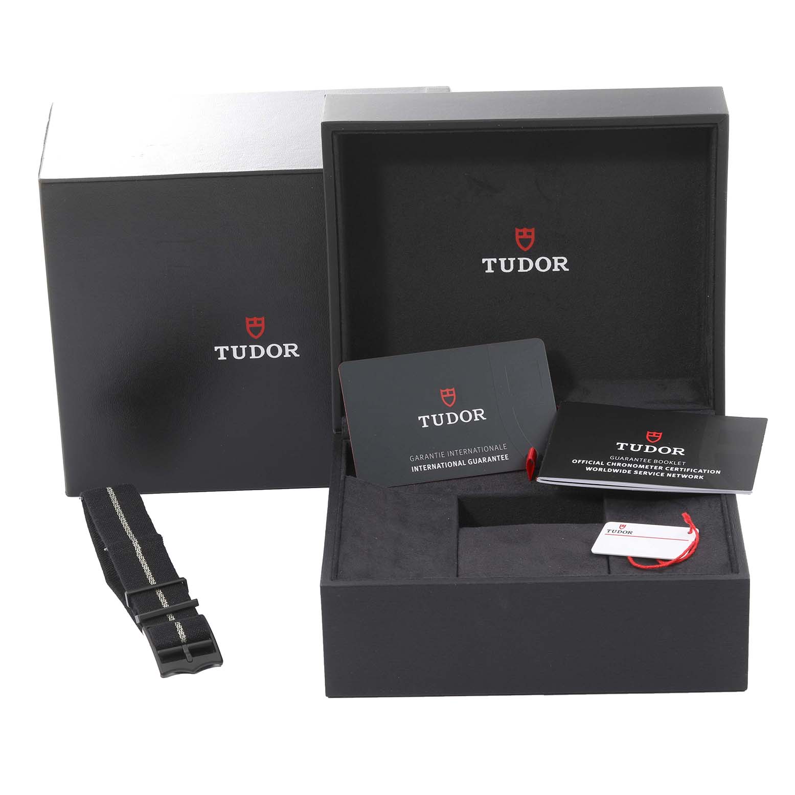 The image shows a Tudor Heritage Black Bay 79210CNU Men
s Ceramic Black Dial 79210CNU Men
s Ceramic Black Dial watch box with a warranty card, booklet, and an additional strap.